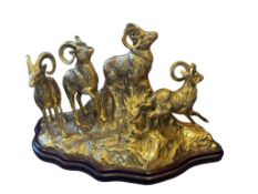BRASS HOLLOW SCULPTURE OF A HERD OF BIGHORN SHEEP ON A ROCKY CLIFF