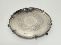 An Edwardian Sheffield presentation scalloped drink tray raised on three claw feet with engraved
