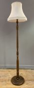 A modern turned wood standard lamp, cream shade raised on turned column on circular base (plug