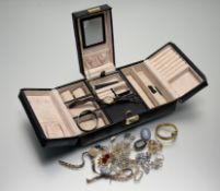 A modern black fold-out jewellery box containing a collection of costume jewellery to include a
