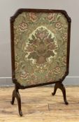 An Edwardian mahogany tilt-top fire screen, with embroidered floral panel to front under glass,