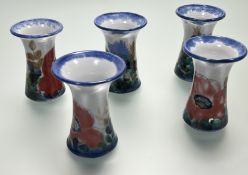 A collection of five Highland Stoneware vases of trumpet-form, decorated with red poppies and