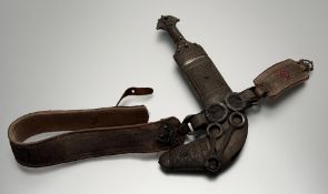 An Eastern jambiya, the horn handle covered in fine white metal filigree work, steel blade (some
