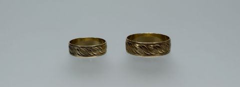 A pair of 18ct gold wedding bands with engraved decoration: larger V 4.43g: smaller N/O 2.9g (2)