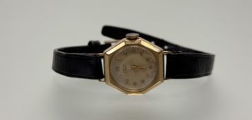 A vintage 9ct gold Hefik wristwatch with champagne dial and roman numerals on black leather strap: