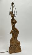 An Indonesian late 20thC table lamp in the form of a carved wooden dancer above a deer (h. 75cm)
