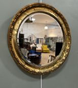 A gilt circular mirror in the 19th Century style with gilt beaded border and bevelled glass plate (