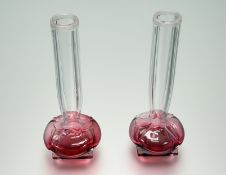 A pair of Edwardian cranberry to clear glass individual bedside bud vases on squared weighted bases: