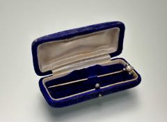 A late 19thc gold stick pin set with a natural pearl within a surround of four rose-cut diamond