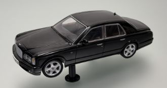 A Minichamps 1/18 scale car model of a Bentley Arnage, raised on twin plastic mounts.