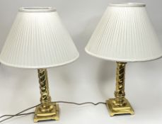 A pair of brass table lamps with twist stems and square stepped bases, complete with cream pleated