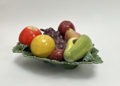 A Mid Century Majolica ceramic fruit bowl in the shape of a leaf, carrying an avocado, grapes, a red