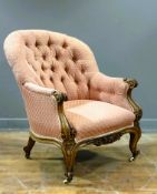 A Victorian light walnut button back drawing room country house style chair, with carved scroll arms