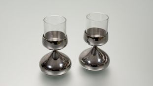 A pair of Robert Welch stainless steel weighted stylish table candle holders with glass inserts: