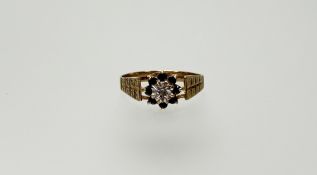 A 9ct gold sapphire and diamond cluster ring the central diamond point with a surround of eight
