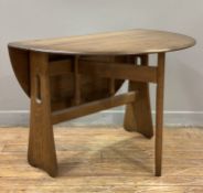 A modern elm drop-leaf dining table by Ercol, oval top with drop-leaves on gate-leg mechanism to