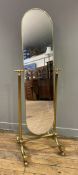 A contemporary brass cheval mirror, arched plate raised on fluted supports and splayed feet with