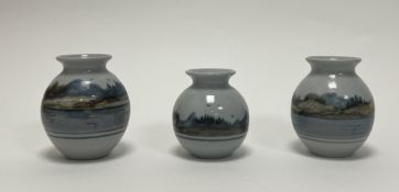 A collection of three Highland Stoneware bud vases of squat form, decorated with Scottish loch
