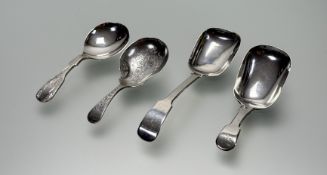 A collection of four loose tea caddy spoons to include a Sheffield silver engraved handle caddy