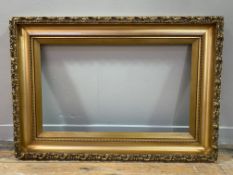 An Edwardian giltwood picture frame with scrolling leaf decoration: Opening H. 45cm L. 75cm