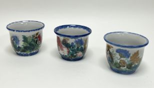 A collection of three Highland Stoneware plant pots, each decorated with poppies and thistles on a