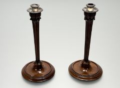 A pair of Italian mahogany tapered fluted table candlesicks in the Napoleonic style with white metal