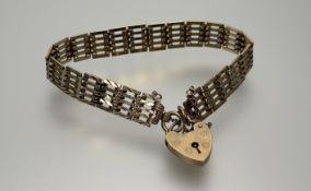 A 9ct solid gold gate link bracelet with 9ct gold heart shaped padlock and safety chain: d. x 8cm