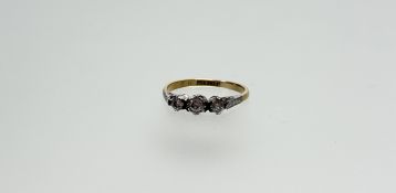 A vintage 18ct gold graduated three stone diamond ring in an illusion setting centre stone 0.07ct
