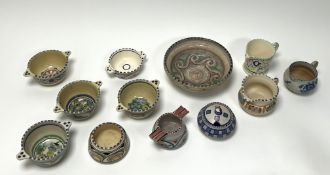 A collection of Honiton earthenwares comprising a varying collection of twin-handled soup bowls with