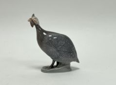 A Danish Royal Copenhagen porcelain figure of a Guineafowl decorated with polychrome enamels on oval