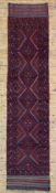 A hand-knotted Meshwani runner, central panel with repeating diamond motifs on a deep red ground: L.