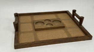 A twin-handled wooden tray with cork base and central raised platform with fitted circles (l. 47.
