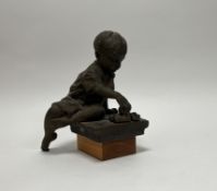Walter Awlson (Scottish 1949): bronzed stoneware sculpture of a seated boy playing with toys, raised
