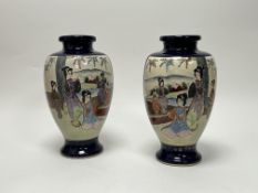 A pair of early 20thC Japanese Satsuma vases, decorated with mirrored panels of figures with gilt