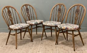 A set of four Ercol elm dining chairs, arched spindle backs and saddle seats, floral seat pads and