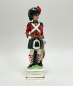 A vintage ceramic decanter in the form of a 19thC Black Watch soldier with cork top (h. 37cm)
