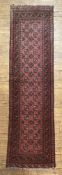 A hand-knotted Afghan Bokhara runner, central panel with two rows of guls, enclosed within a