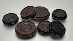 A collection of various chinese carved wooded circular stands, one has losses to base. (7)