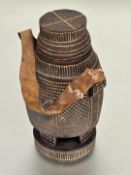 A Somali carved wood milk flask with chip wood decoration of mallet shape, raised on four carved
