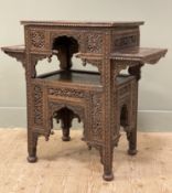 A late 19th/ early 20th century Indian hardwood table, heavily carved top with foliate border and