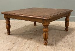 A modern solid oak coffee table, square plank top raised on fluted turned supports (a/f mark to