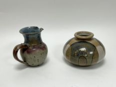 A studio pottery vase of squat form, decorated with mottled blue brown and white abstract forms,