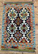 A hand-knotted Chobi kilim rug, central panel with repeating diamond medallions, deep navy ground