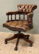 A reproduction captain's desk chair, rolled top with brown leather button-back and seat, on