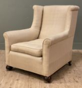 A good Edwardian wingback armchair, cream linen upholstery and raised on bun feet with castors (a/