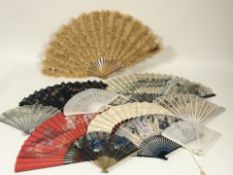 A quantity of ladies costume fans varying from a feather wooden fan, a white plastic fan,