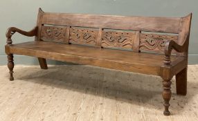 A modern Thai teak bench, with four carved panels to back and shaped arms over a plank seat,