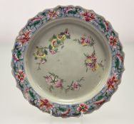 A late 19thc Chinese Famillie Rose enamelled celadon ground dish. (chip to edge) (w-28cm)