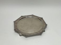 A George V Birmingham silver octagonal drinks tray with scroll fluted rim raised on four scroll