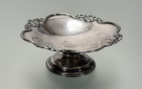 A George V Birmingham silver pistachio dish with ribbon cast scalloped edge on circualr stepped